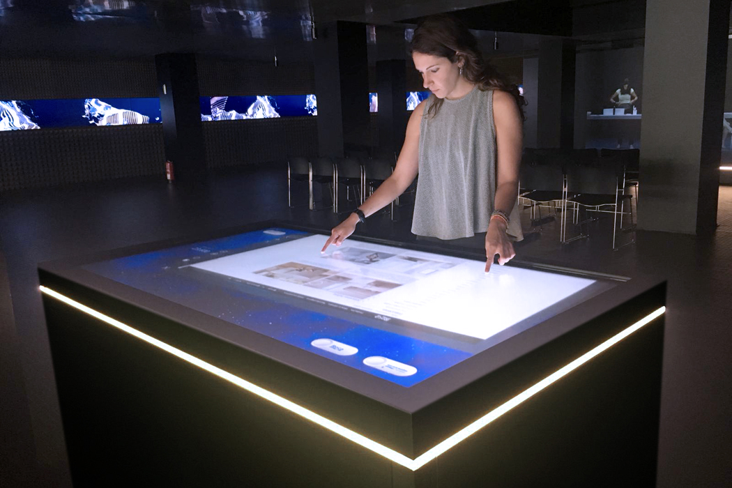 Tables and interactive screens in the Roca Gallery to explain the history and values of the brand