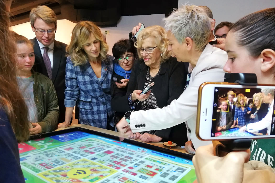 La alcaldesa de Madrid, Manuela Carmena, viendo el funcionamiento del juego Cleanairs sobre la mesa interactiva XTable.