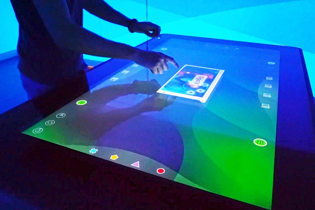 Recursos compartits en sala immersive des de taula multitouch.